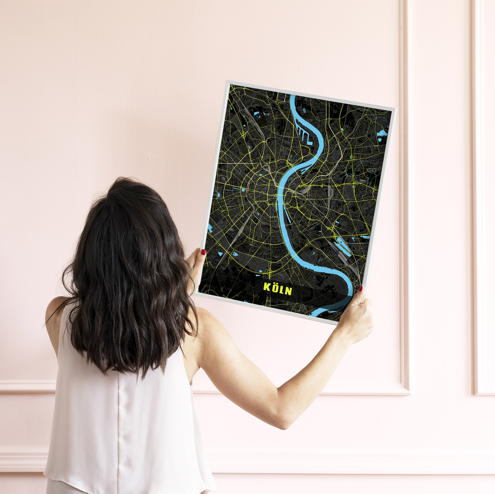 Köln-Stadtplanposter mit weißem Rand, türkisblauem Rhein und neongelben Straßen vor einer hellrosa Wand