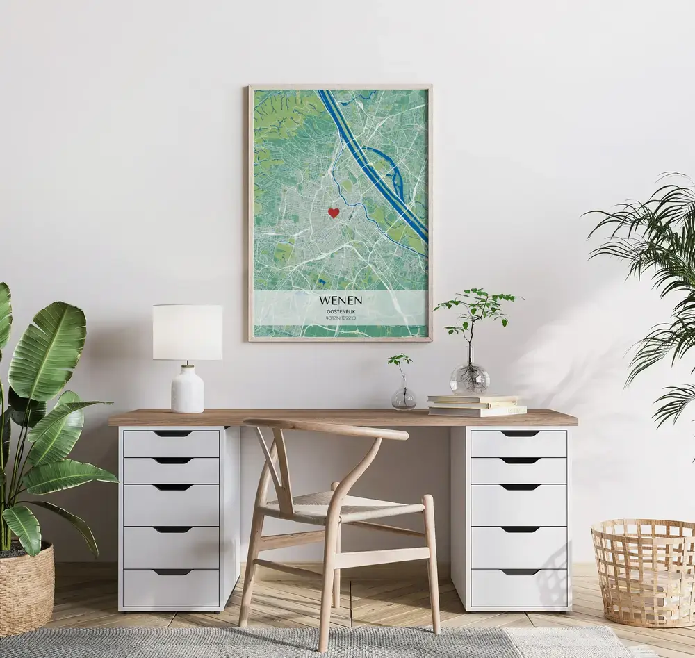 Groen-blauwe stadskaartposter met lichte coördinatenbalk en hartmarkering, in een houten lijst boven het bureau